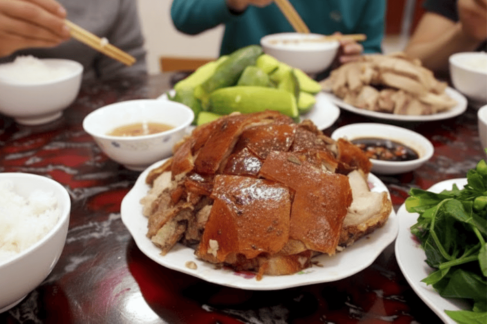 Slices of crispy pork skin and moist meat, served with chili salt and local herbs